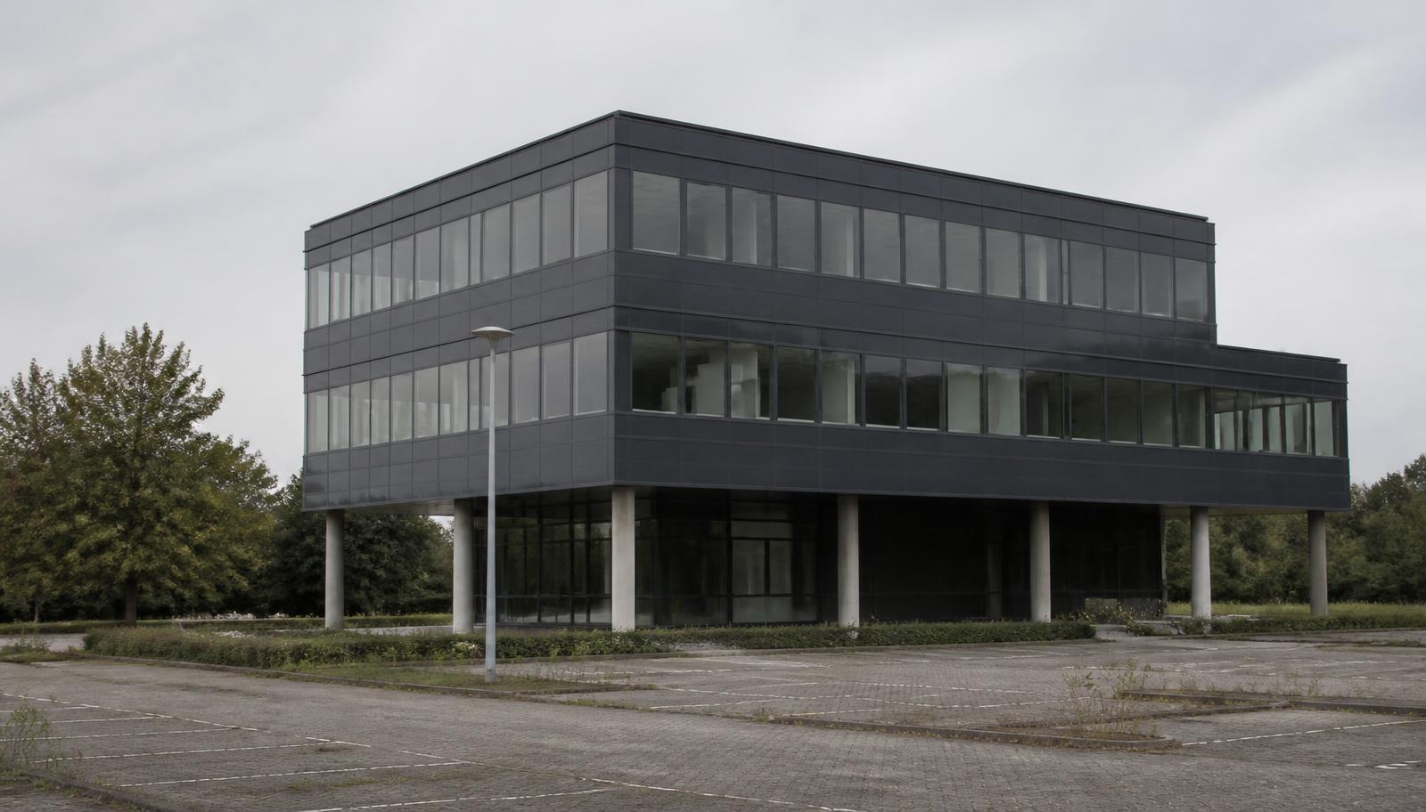 Leegstaand kantoorgebouw met verlaten parkeerterrein